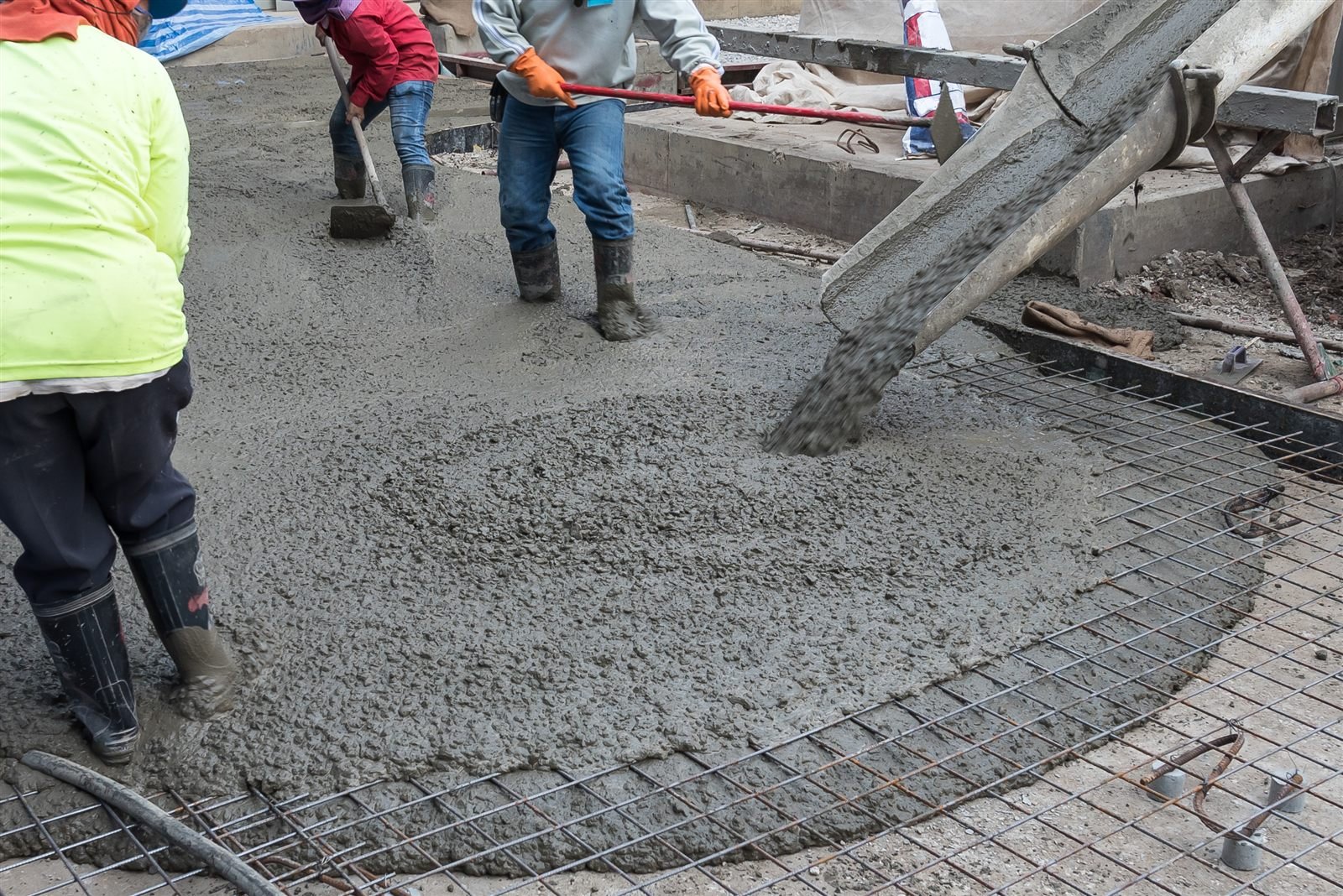 Concrete being poured over steel wire mesh reinforcement for a slab in Omaha, NE